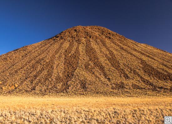 Vulkan im Abendlicht in der Namib-Wüste mit Streifenzeichnung
