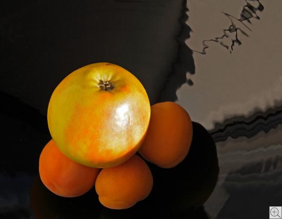 Stillleben mit Apfel und Aprikosen auf spiegelndem schwarzen Grund