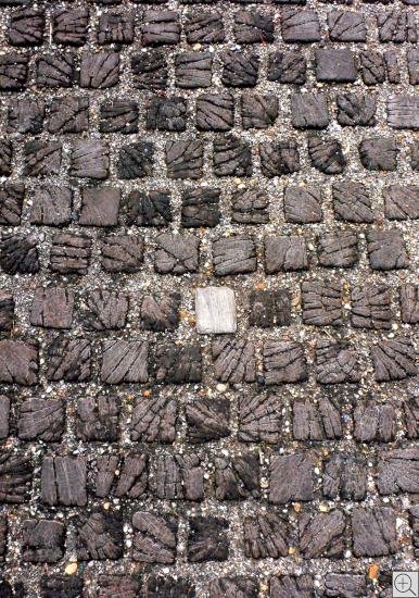Nahaufnahme eines Holzpflasters mit hellm Stein in der Mitte