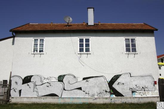 weisses Haus mit grauen Graffiti in Johanneskirchen