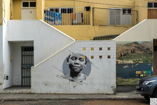 Hausansicht in abstrakter Linienführung, mit Graffito und Plakat "Cabo Verde"