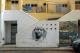 Hausansicht in abstrakter Linienführung, mit Graffito und Plakat "Cabo Verde"